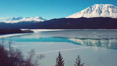 video de drones de 4k de montañas cubiertas de nieve junto a un lago en alaska durante el invierno