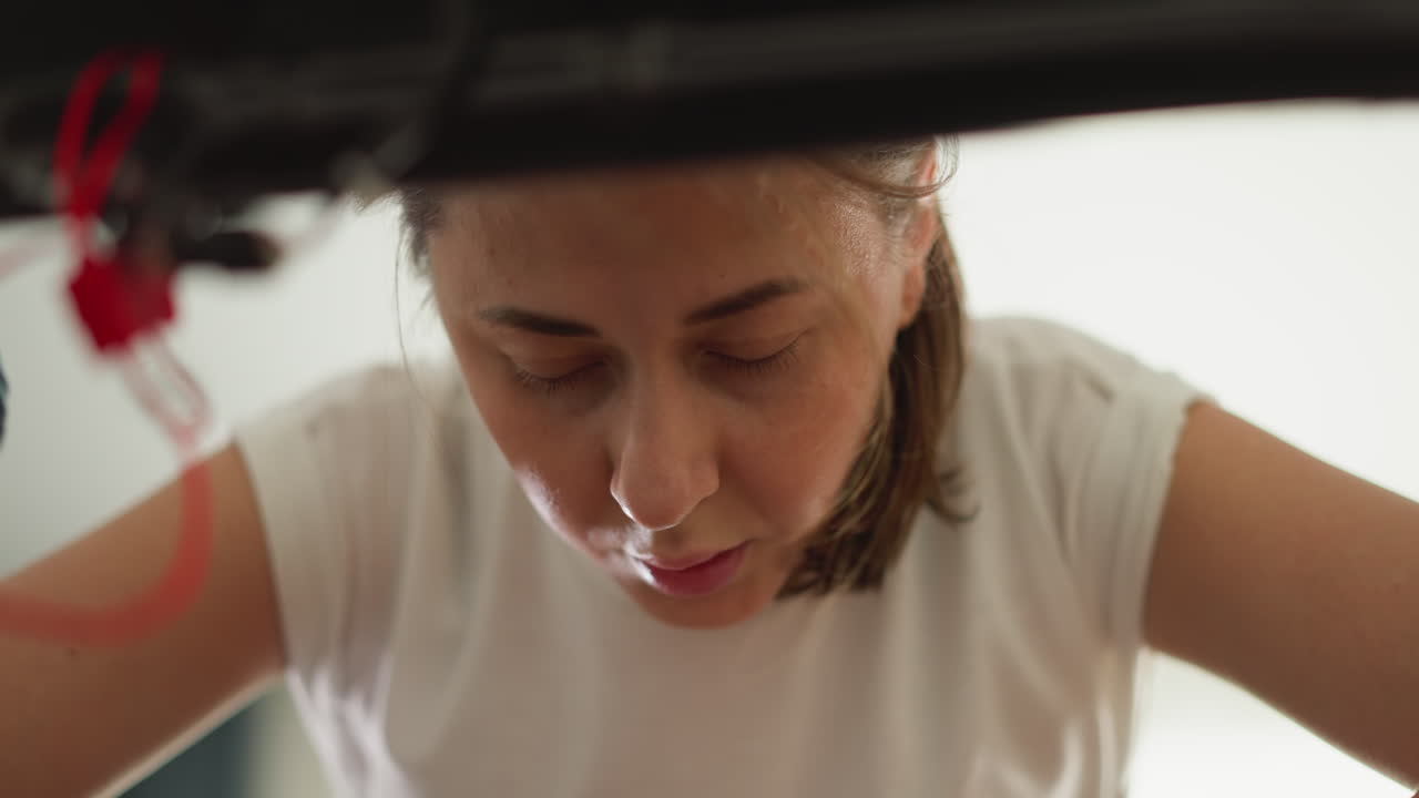 Sad woman rests on treadmill in gym closeup. Fatigued lady breathes heavily leaning on trainer at home. Sportswoman tired of hard physical training