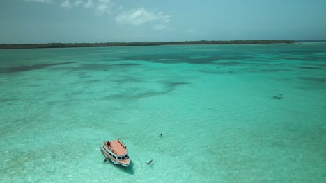 Aerial-view-of-a-glass-bottom-boat-anchored-in-the-crystal-clear-waters-of-Nylon-Pool,-Tobago