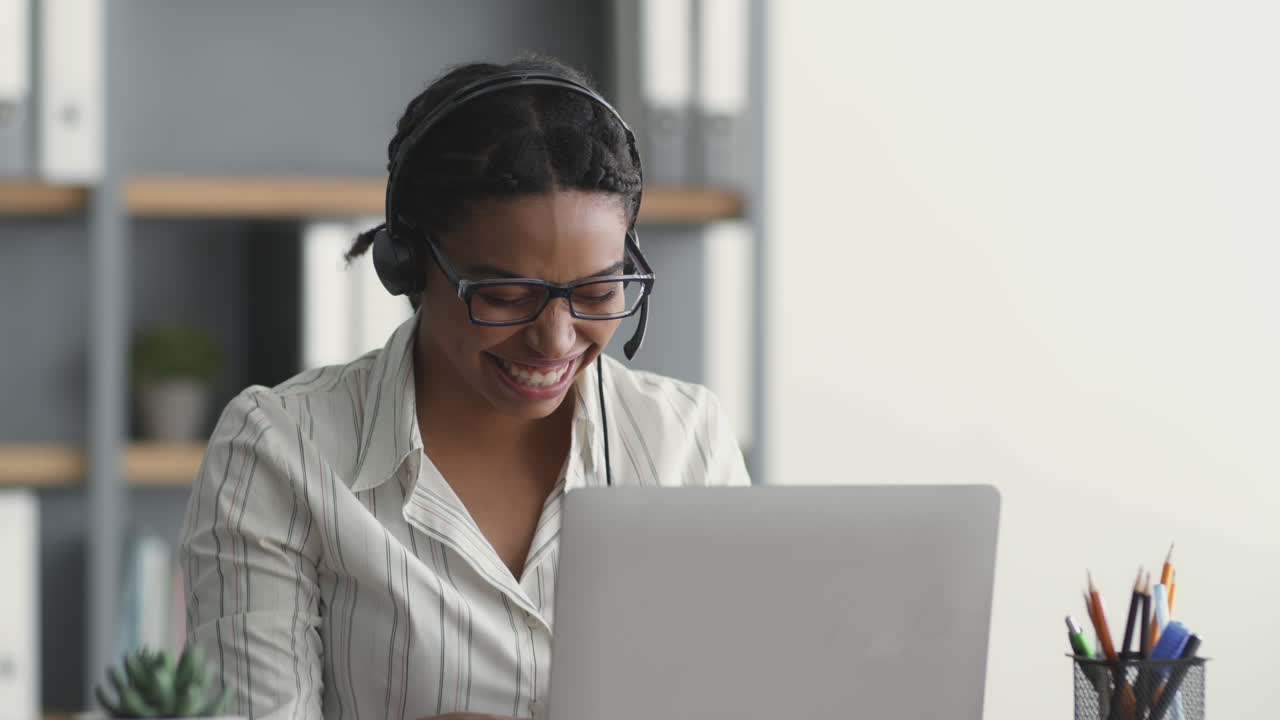 Donna che lavora al computer con le cuffie