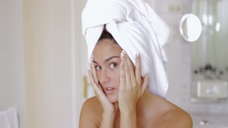 Headshot-of-young-pretty-woman-with-towel-on-head-looking-at-camera