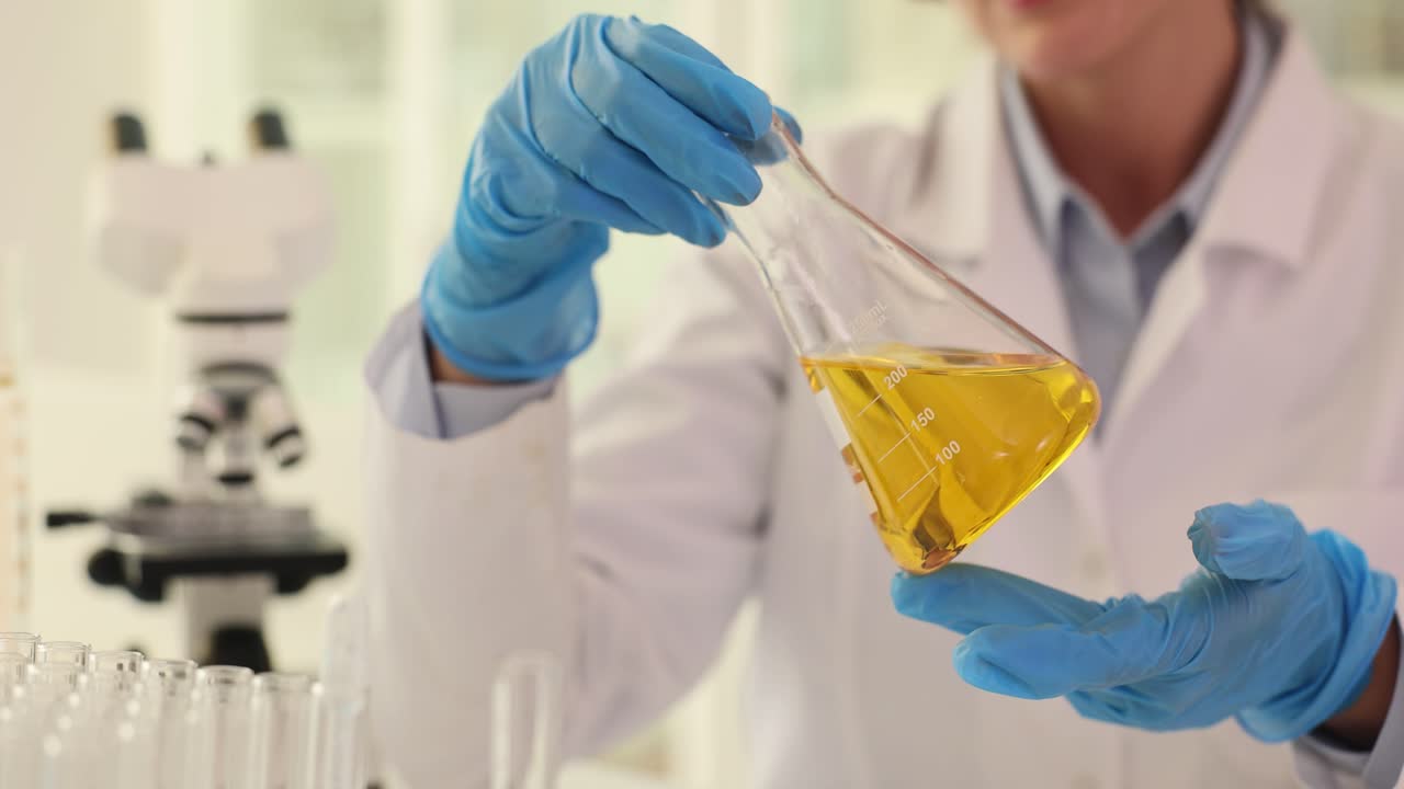 Scientist working with a yellow liquid in a laboratory