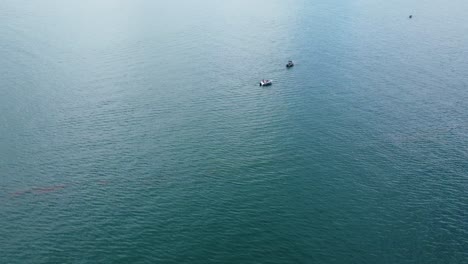 drone flying away from fishing boats on the ocean