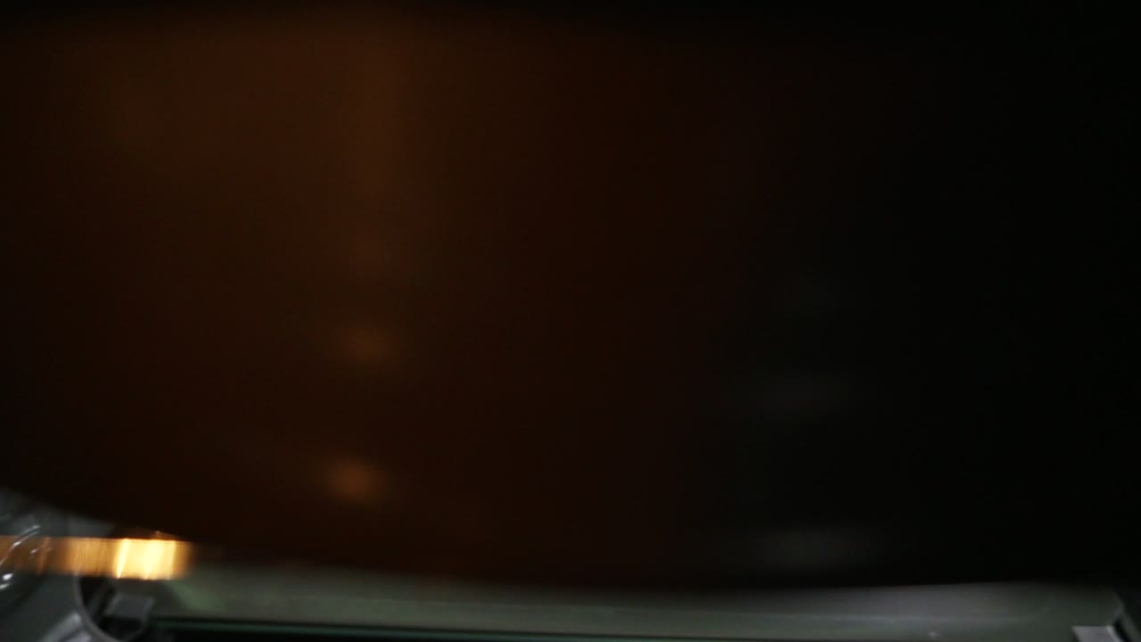 View from the oven: woman opens the oven's door and puts a baking pan inside. Beautiful girl in her kitchen puts her cake into
