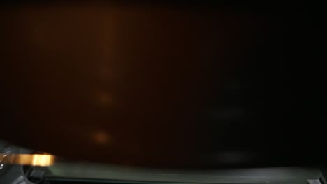 View from the oven: woman opens the oven&#039;s door and puts a baking pan inside. Beautiful girl in her kitchen puts her cake into