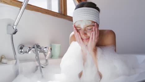 woman washing her face mask in bathtub