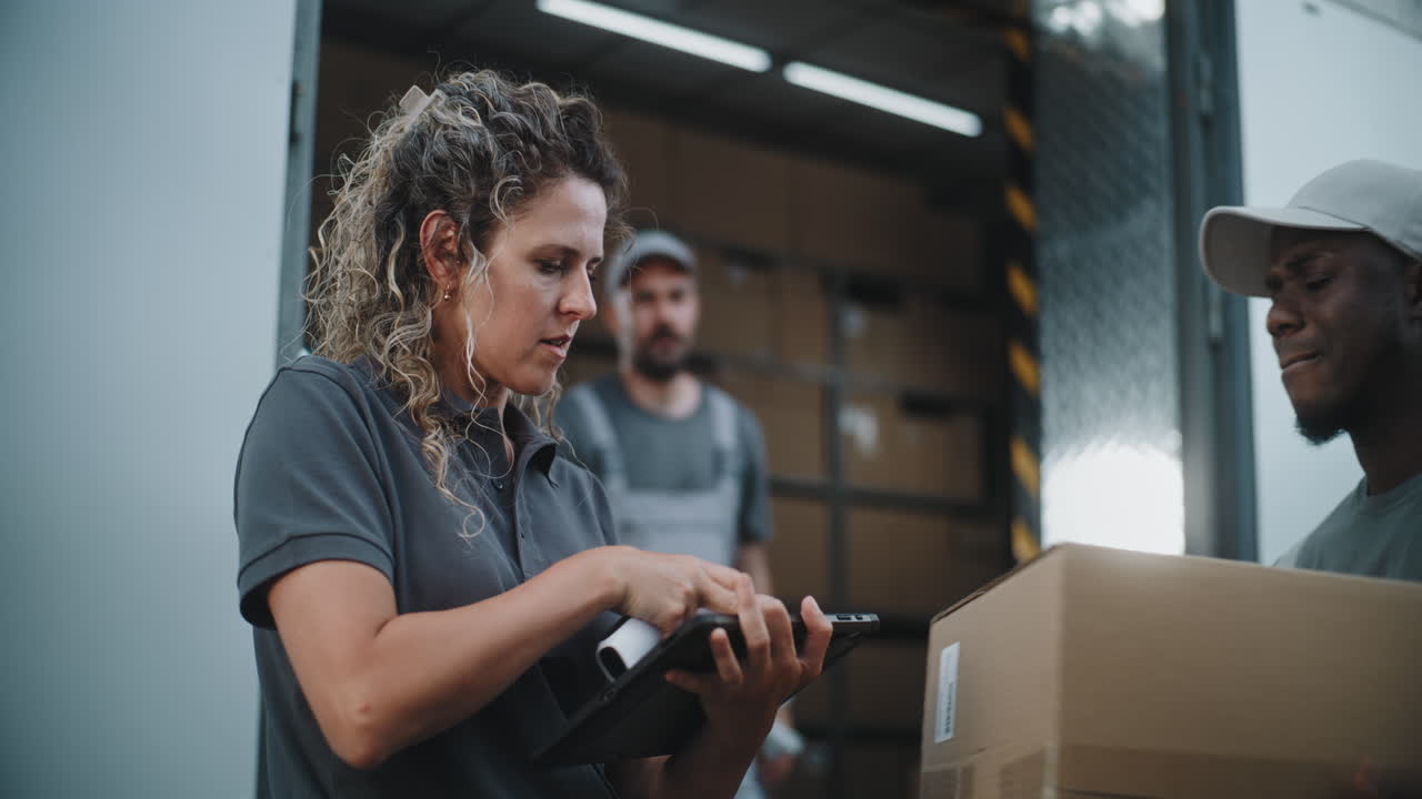 Logistics team managing inventory and deliveries with barcode scanner and tablet