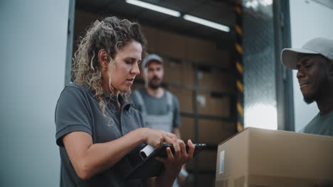 logistics team managing inventory and deliveries with barcode scanner and tablet