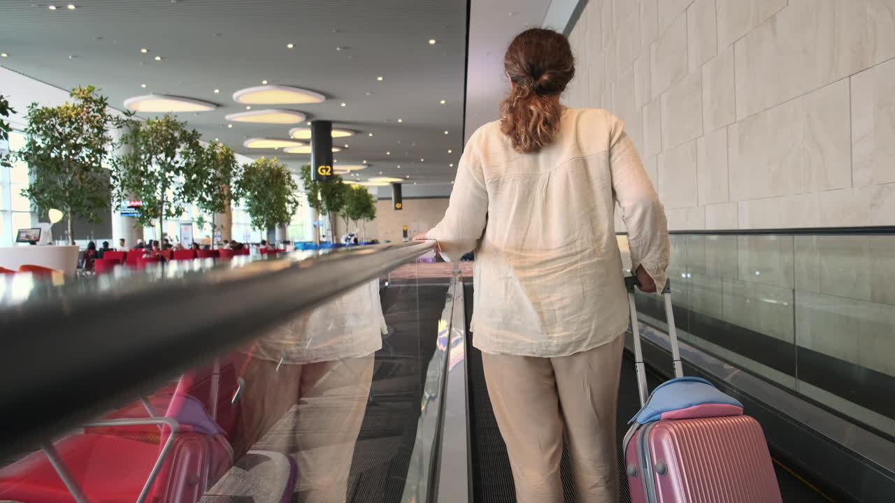 mujer caminando por el aeropuerto moviéndose por la pasarela con equipaje