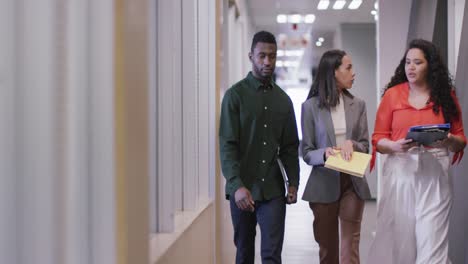 Happy-diverse-group-of-business-people-working-together,-walking,-discussing-work-in-modern-office