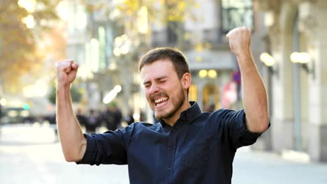 excited man raising arms in the street