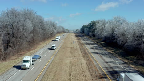 vista aérea estática sobre la carretera interestatal rural mientras pasan los camiones, 4k