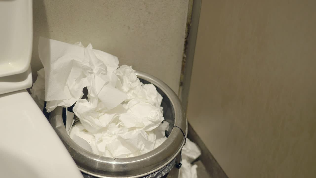 Used Tissues in a Trash Can in a Bathroom