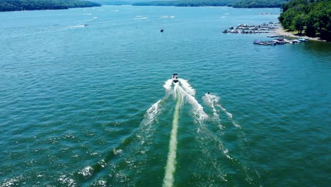 birds eye view of tourists enjoying water skiing, tied behind high speed motor boat