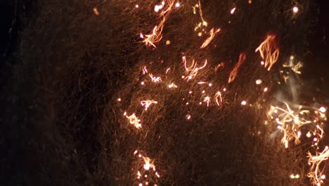 Hypnotic-steel-wool-burning-sparkles-in-darkness-round-bokeh