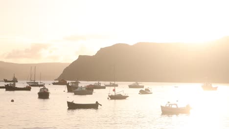 Barcos-Flotando-En-Un-Puerto-Que-Fluye-Al-Atardecer-En-Portree-En-La-Isla-De-Skye,-Tierras-Altas-De-Escocia.