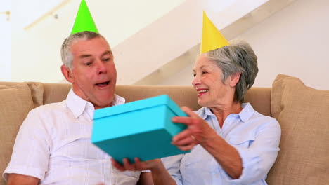 senior couple sitting on couch celebrating a birthday