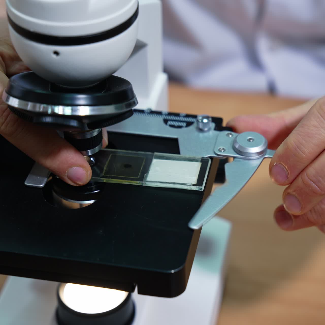 Laboratory researcher puts the sample under the microscope. Medical laboratory at modern hospital. Close up