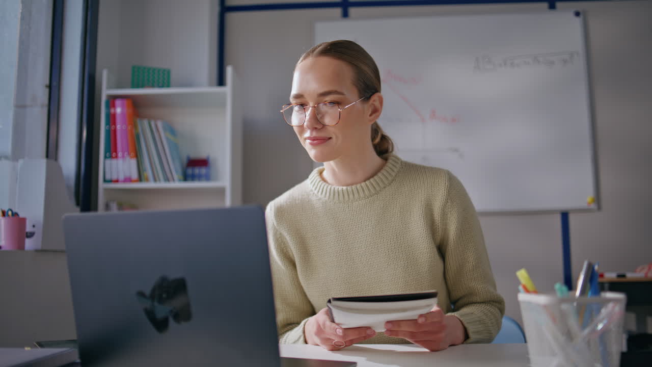 Smart woman conducting online lesson looking laptop screen at classroom closeup