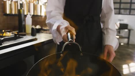 chef cooking vegetables with fire