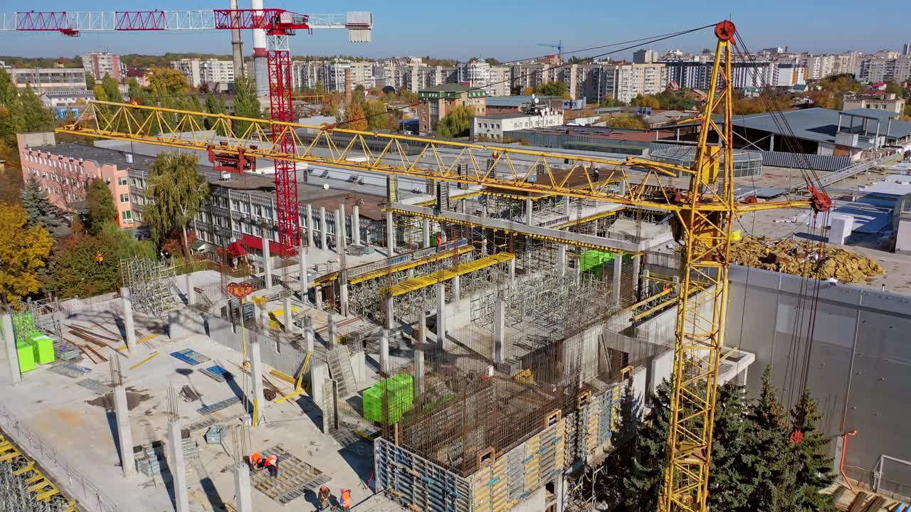 Cranes and building construction site. Aerial view of tower cranes build large residential buildings