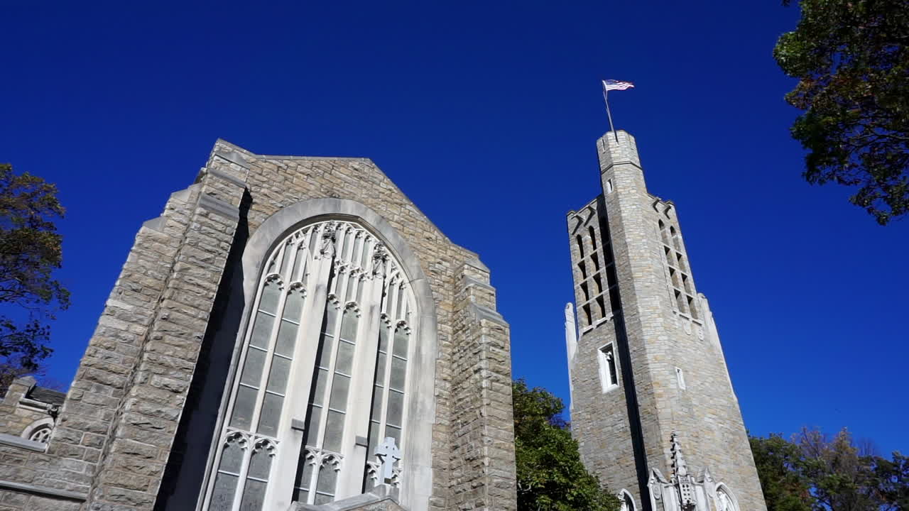 Gothic style bell tower and church with stained glass window.