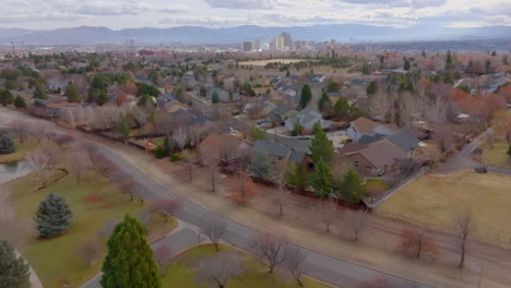 Flyover-suburban-sprawl-in-Reno-Nevada-and-towards-city-skyline-with-backdrop-of-mountains-on-a-beautiful-winter-day