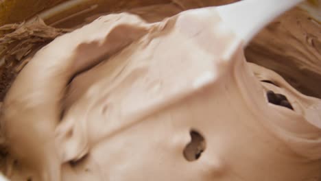 mixing chocolate chips into cake dough with a cake hand mixer - close up