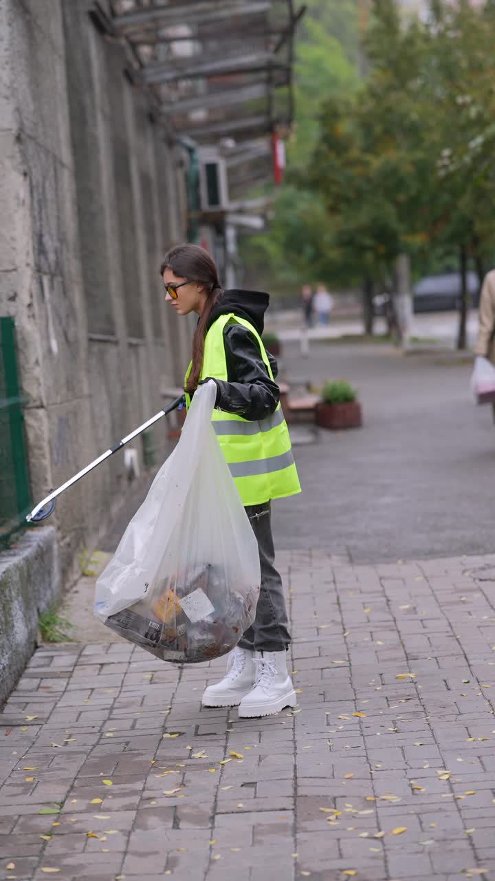 mujer limpiando la basura en la ciudad