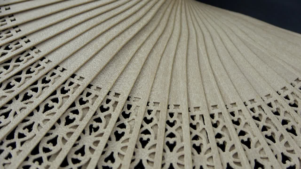 un semicírculo con un abanico hecho de madera con pequeñas tallas finas