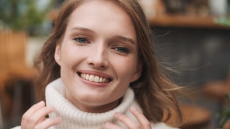 una mujer caucásica sonriendo a la cámara.