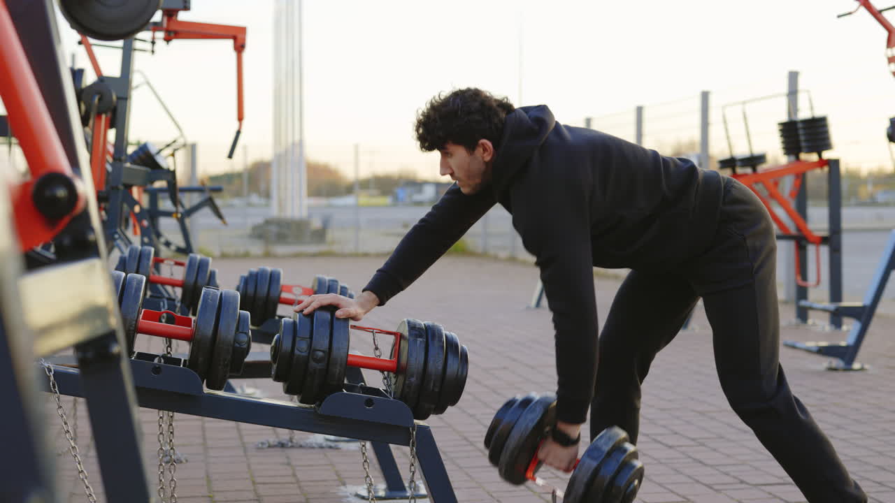 야외 에서 덤벨 을 사용 하여 운동 하는 사람