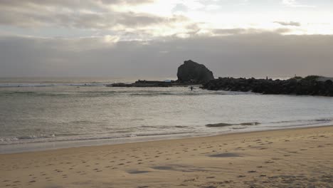 Surfistas-En-La-Playa-De-Currumbin-Durante-La-Puesta-De-Sol---Costa-De-Oro,-Qld,-Australia---Plano-General