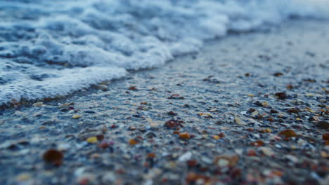 Macro-blue-sea-water-splashing-seashell-sand-beach-in-slow-motion.-Sea-waves