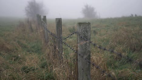 Stacheldrahtzaun-Auf-Ackerland-An-Einem-Nebligen,-Nebligen-Tag,-Weitwinkelaufnahme