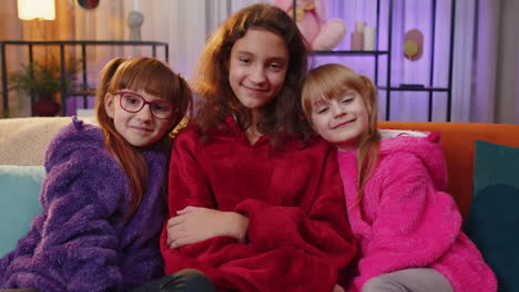 portrait of happy smiling teenage child and little sisters kids looking at camera at home play room