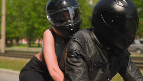 Young-woman-hugs-boyfriend-riding-motorcycle-together