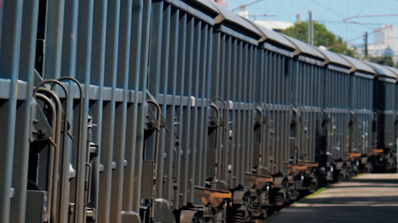 Close up of a grey train moving on the rails in daylight