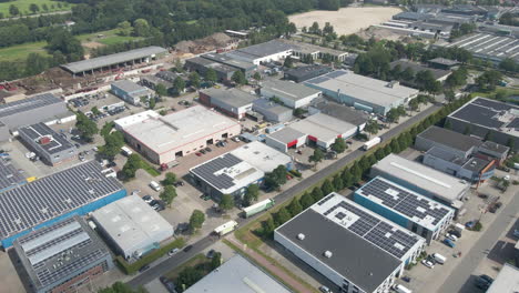 aerial of busy industrial site with multiple buildings with photovoltaic solar panels on rooftop