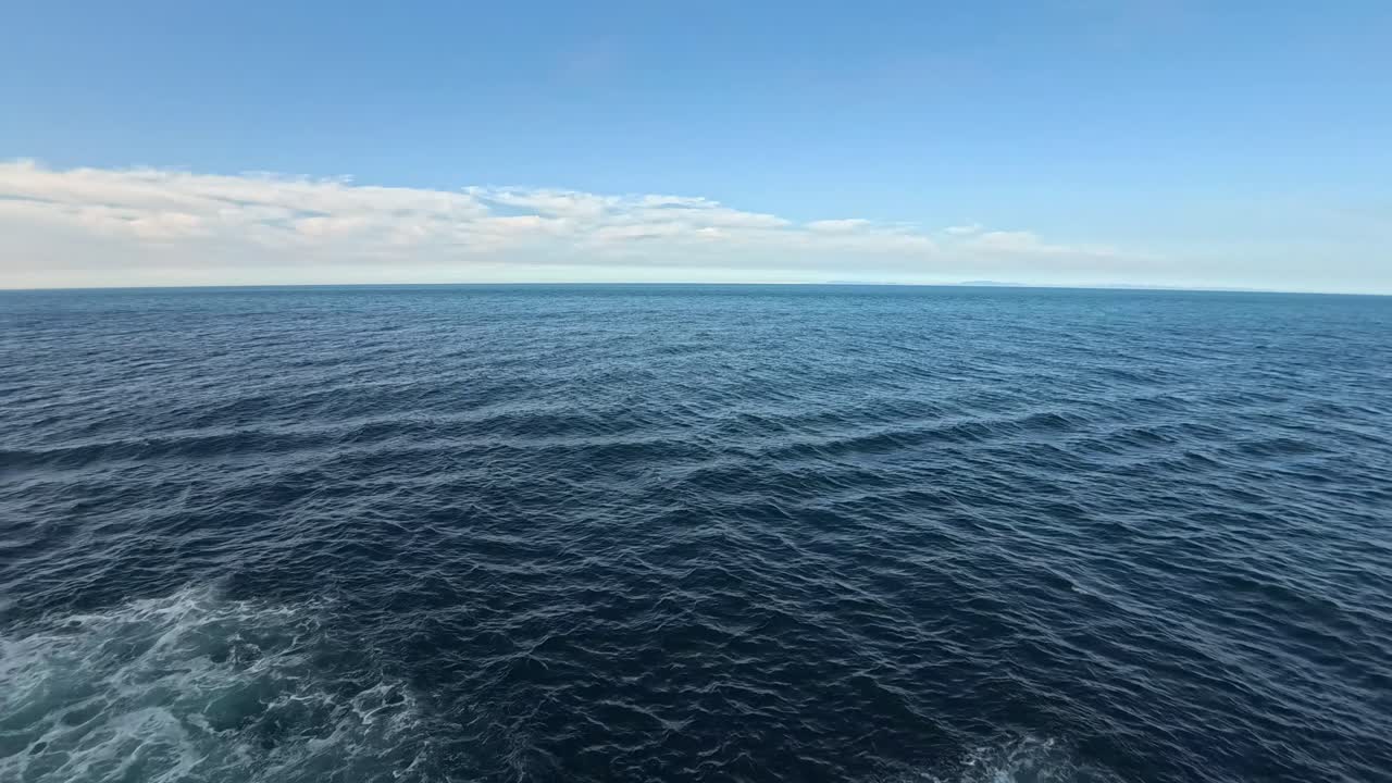 Vasto oceano blu con onde dolci e cielo sereno