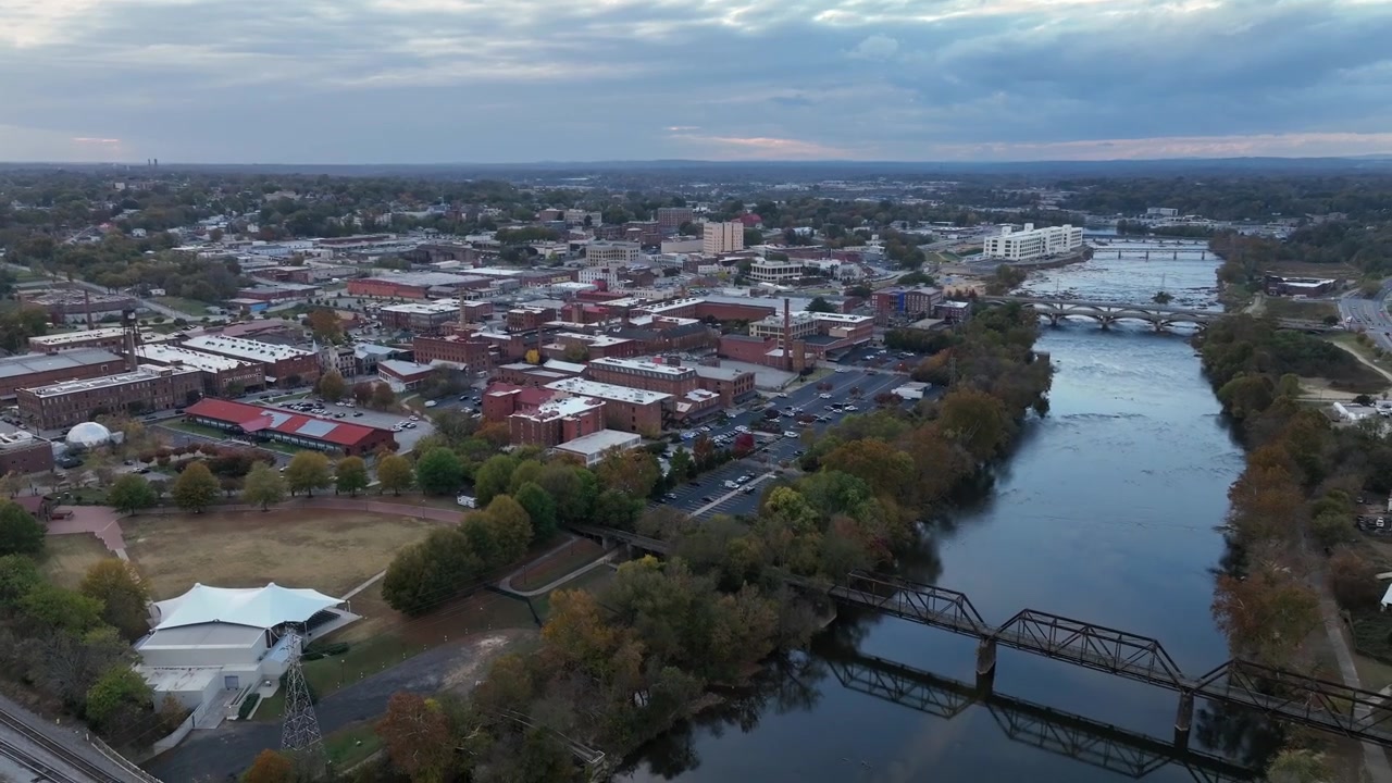 Inquadratura aerea di presentazione di una città storica in America, vicino al fiume e traffico sull'autostrada. Giornata nuvolosa in autunno. Case e appartamenti in stile mattoni rossi. Campo lungo