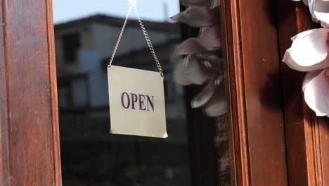 signo abierto en una puerta de tienda de madera