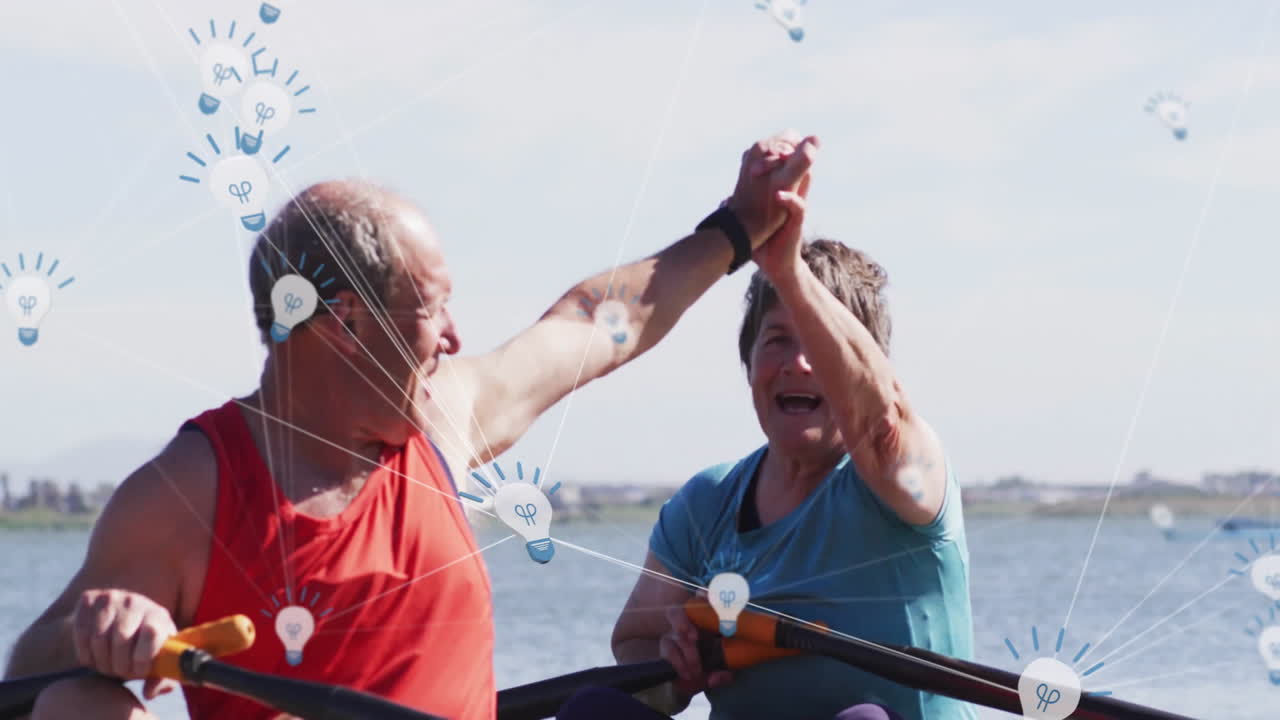 Male and female rowers rowing and high?fiving on lake boat, featuring technology light bulb icons