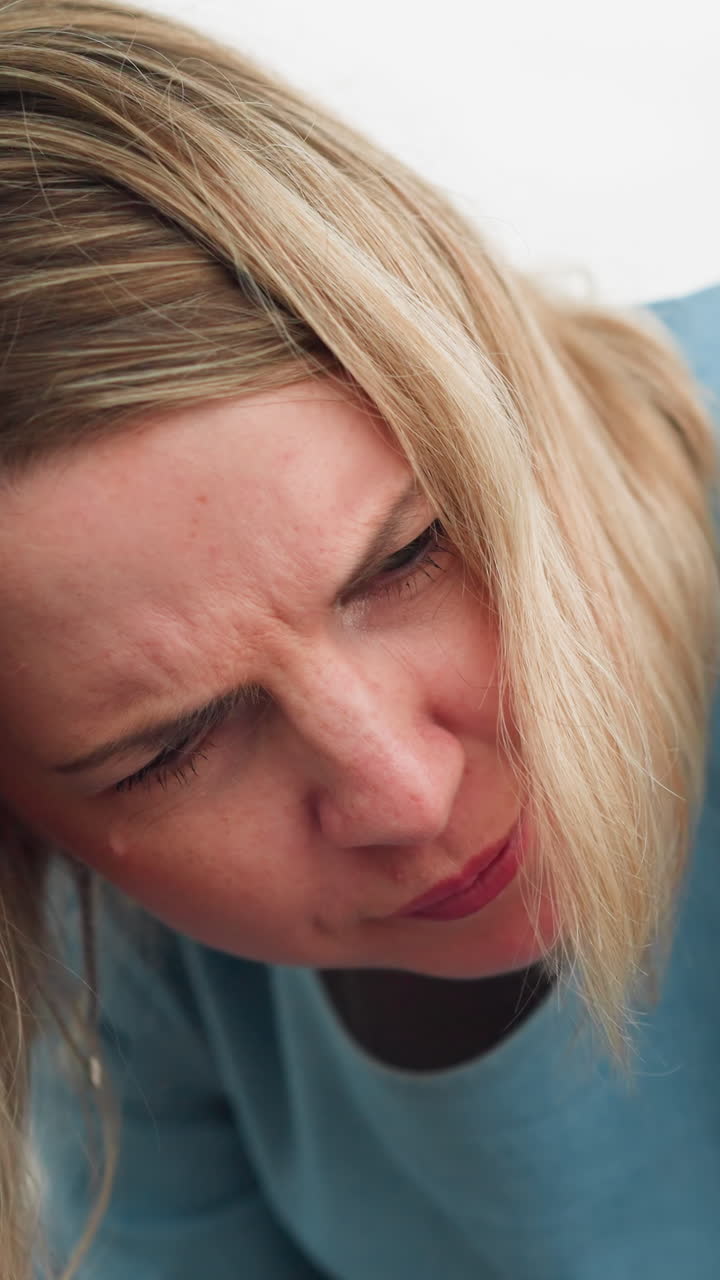una mujer se inclina hacia adelante con una expresión concentrada, dirigiéndose a alguien parcialmente visible en el fondo