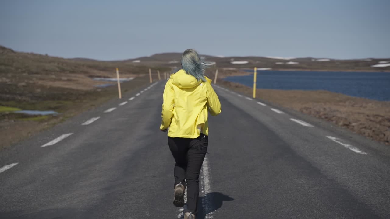 This was taken at a higher frame rate and has been converted to a slow motion video clip.  Lady running on the middle of a two way road in Iceland. Very dramatic.