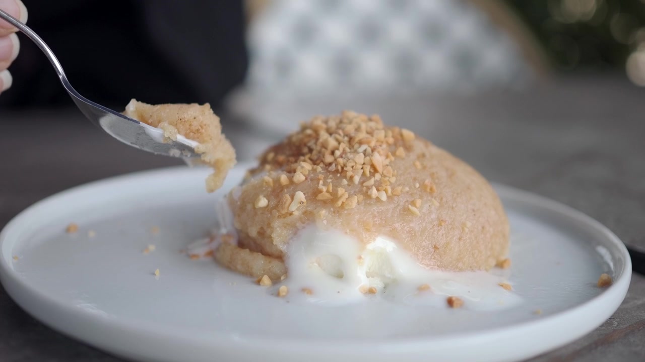 Person isst Grießhalva mit Eiscreme