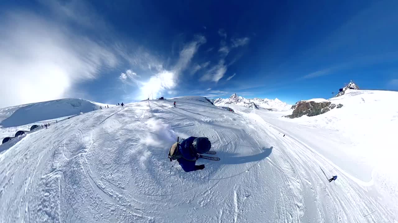 Young man skiing energetically down piste with blue skies