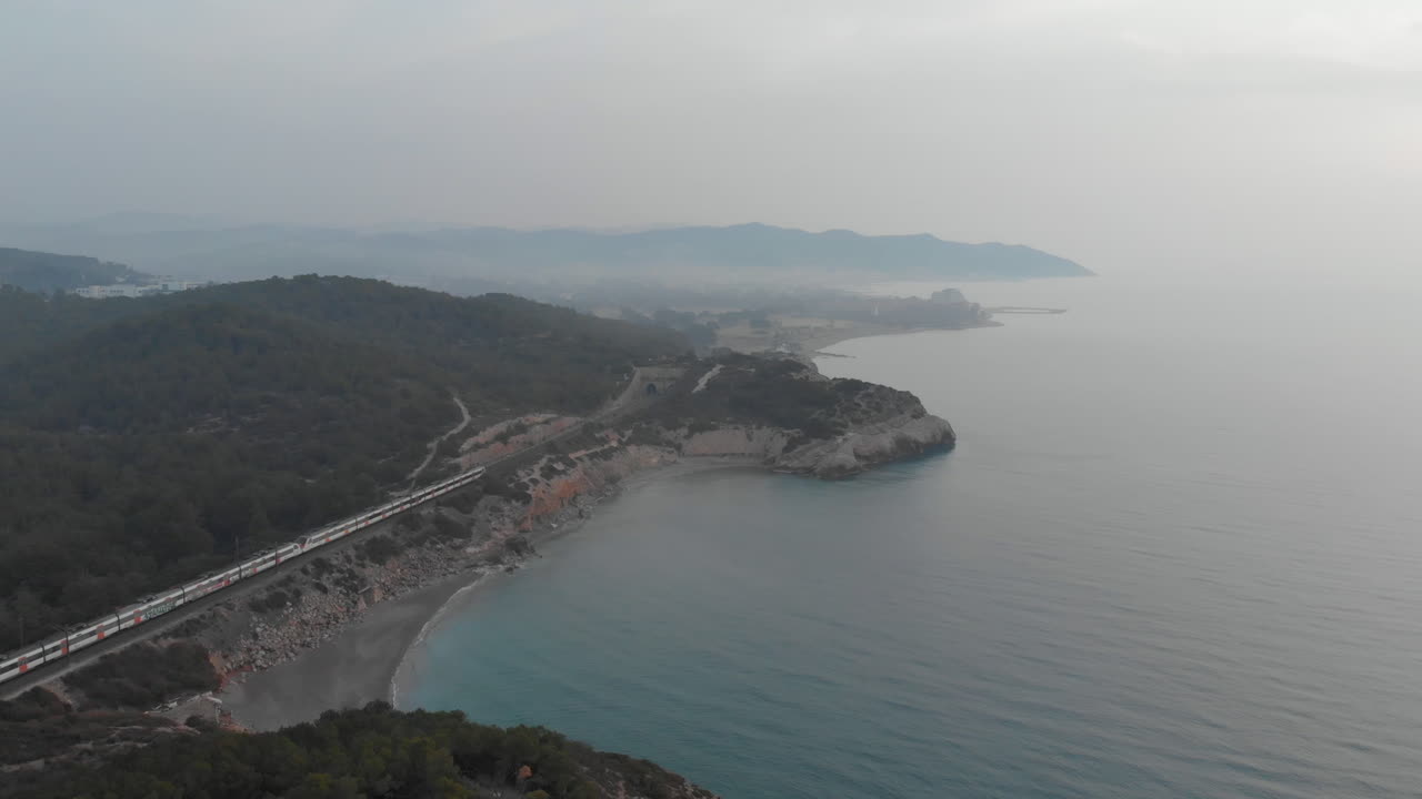 drone volador sobre la costa rocosa mientras pasa el tren