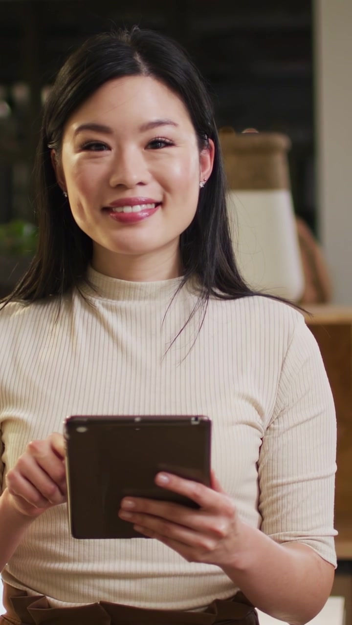 Video verticale: Donna di mezza età che tocca un tablet, con sovrapposizioni di codice che scorrono mentre esamina la tecnologia.