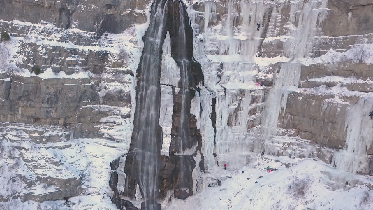 escaladores de hielo escalan una cascada congelada en condiciones extremas - agrandando